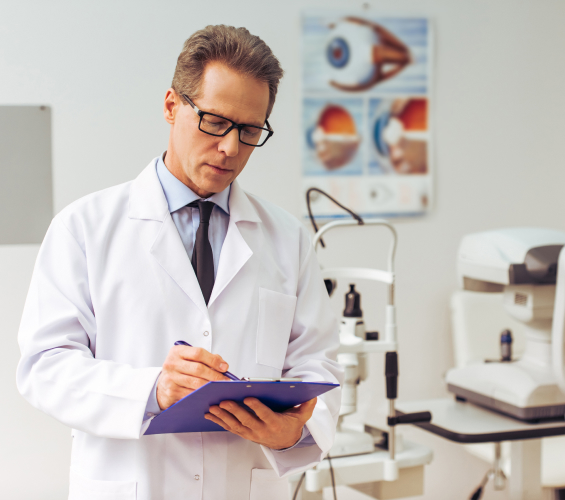 A doctor in a white labcoat wearing glasses takes notes.